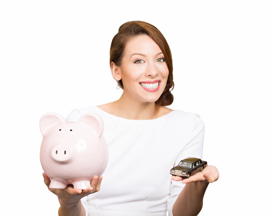 Closeup portrait, beautiful, young woman, dealership agent holding model black car, pink piggy bank in hand, offering credit line, isolated white background. Lease, automobile purchase, financing.